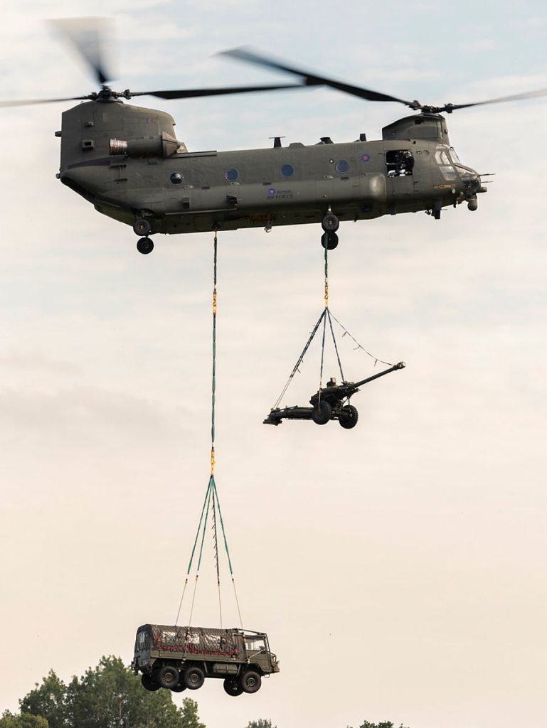 イギリス空軍のCH-47に吊り下げ輸送をされるL118 Light GunとPinzgauer 6x6